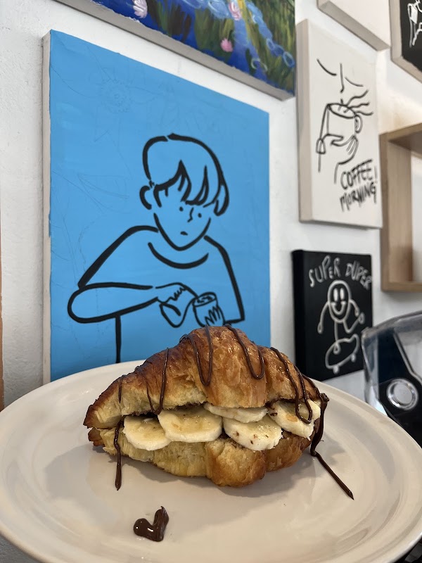 Espacio de Brushtroke Arte y Café con obras cerámicas en la pared y una taza de café filtrado