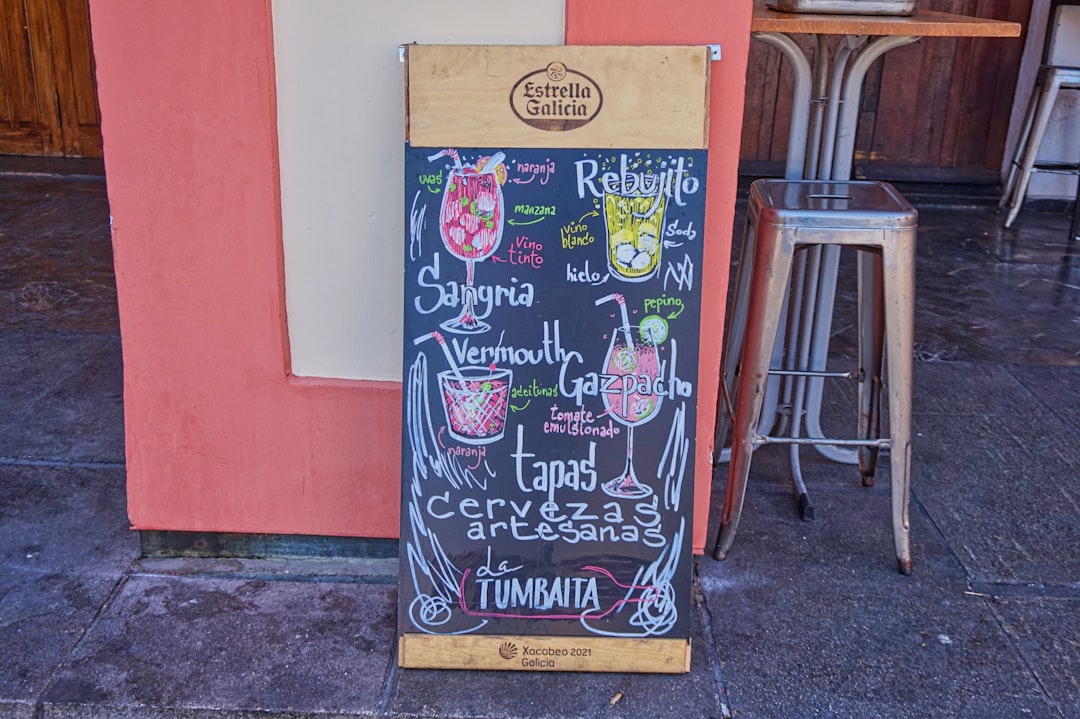 A chalkboard sign sitting on the side of a building