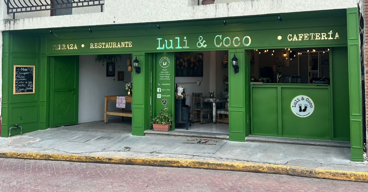 Exterior de Restaurante y Cafetería Luli y Coco con su colorido letrero y mesas al aire libre