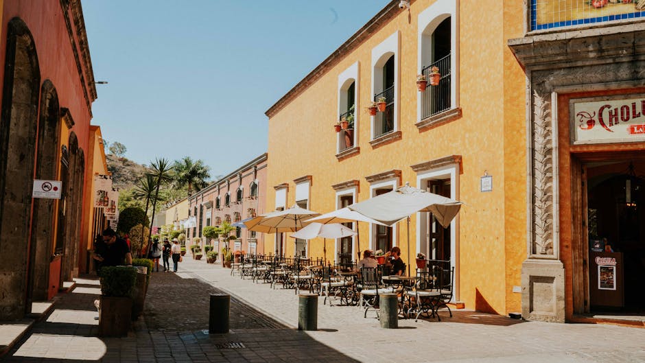 Vibrant street scene in Mexico featuring outdoor dining and colorful architecture.