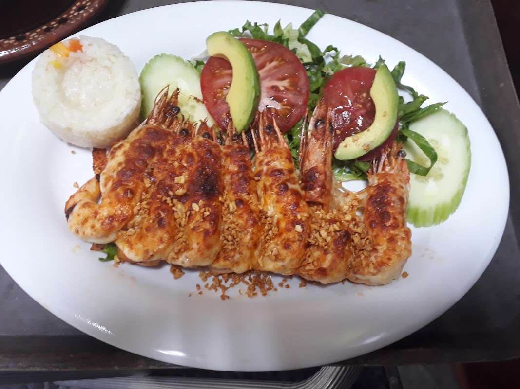 Plato de mojarra a la talla en Siete Gambas, presentado en plato blanco con guarnición de verduras.