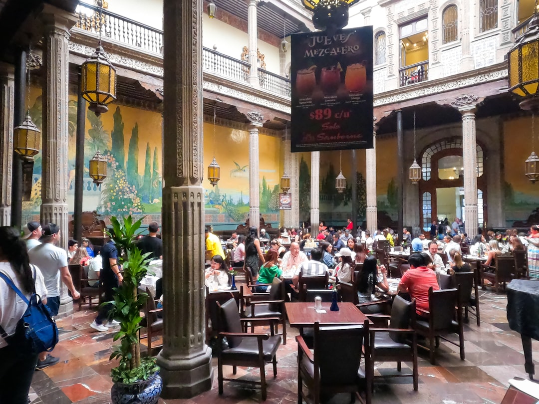 a large group of people sitting at tables in a restaurant