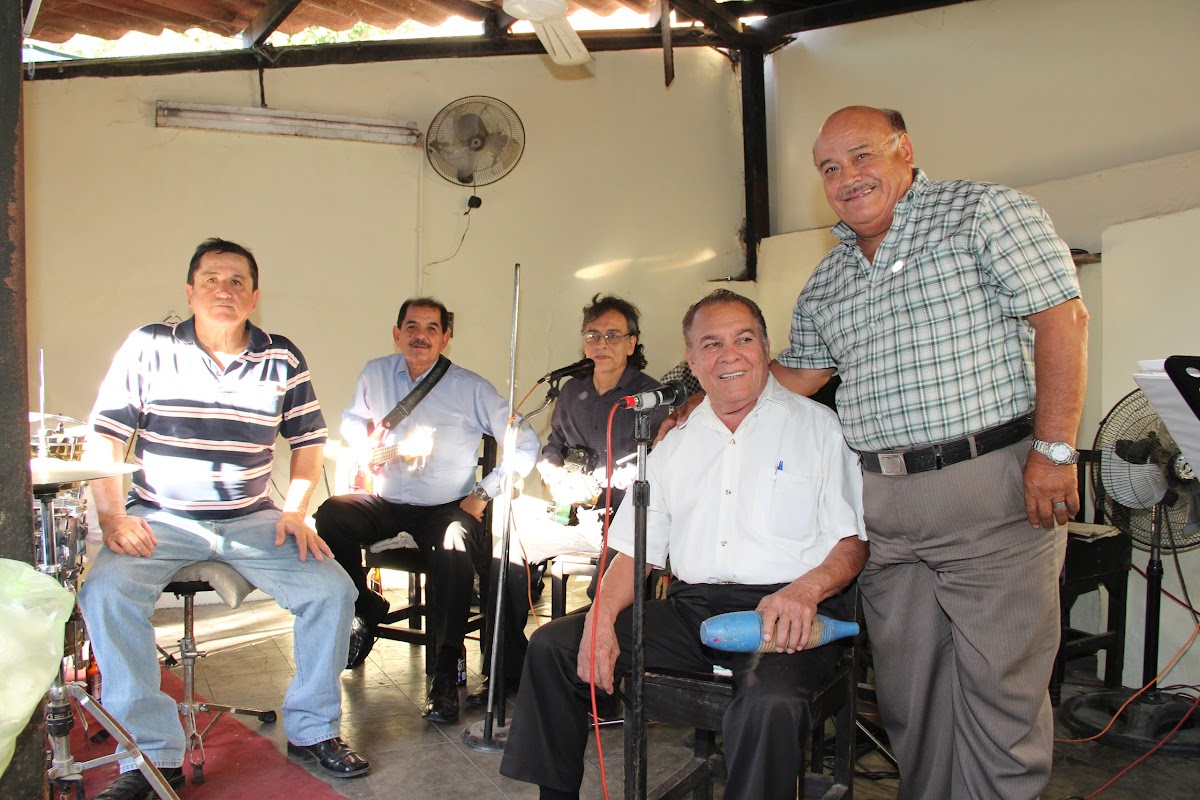 Bar El Guayabo con parrilla de pollo y papas, ambiente de cantina y música en vivo, foto del mostrador y botellas