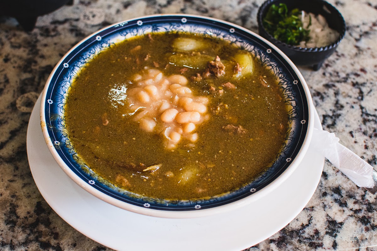 Guisos Doña Julia – gorditas de chicharrón con salsa verde en plato de cerámica, mostradas en una mesa de madera