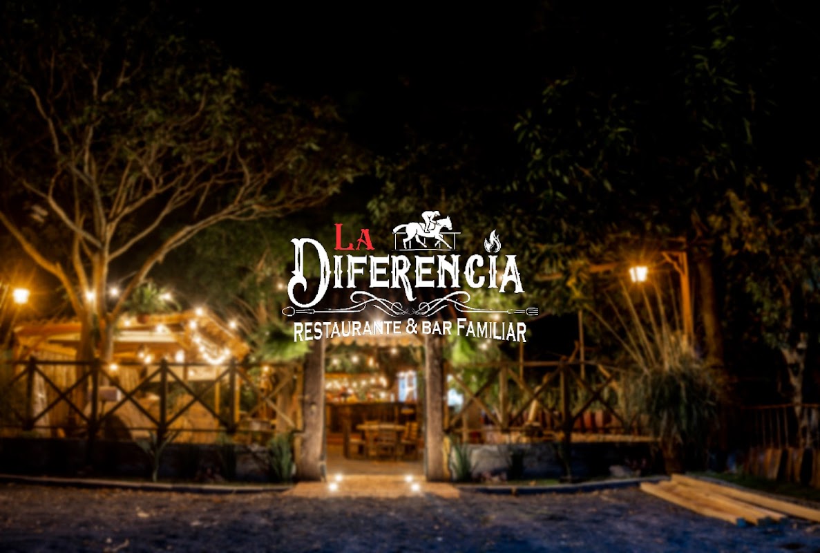 La Diferencia Restaurante & Bar – fachada iluminada con luces de neón y barra de madera bajo la entrada