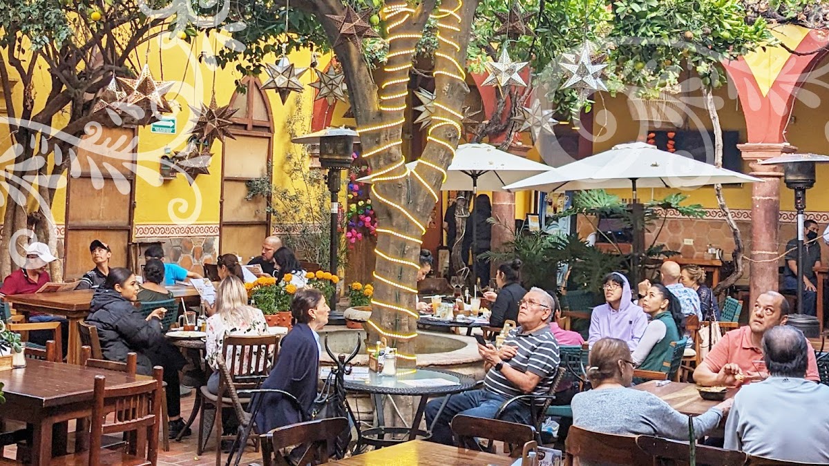 Patio con músicos en El Fruty Restaurante — foto del espacio al aire libre con mesas y guitarrista