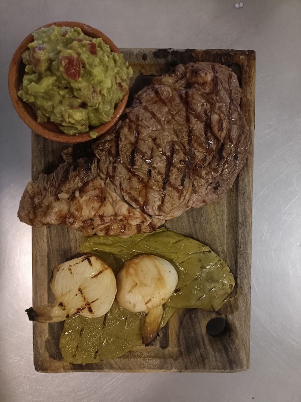 La Patrona interior con parrilla encendida y un corte de arrachera en plato