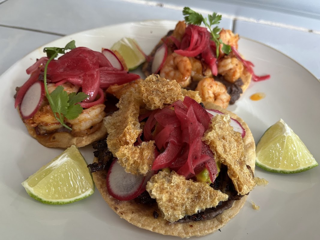 Tostada de ceviche en -EL PASILLO-, con camarones, aguacate y salsa verde, tomada en primer plano