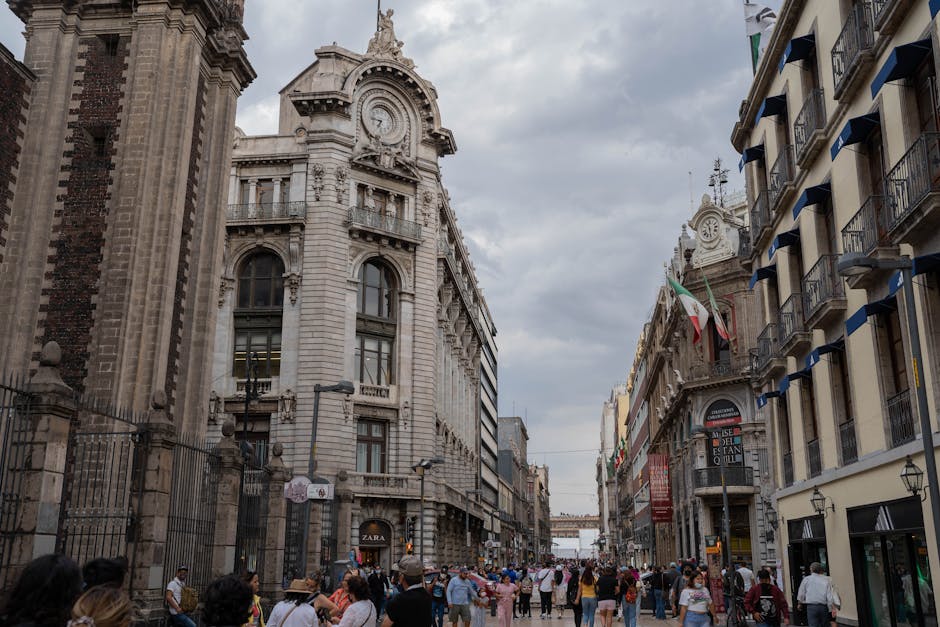 Vibrant scene of historic buildings and bustling crowd on Madero Street in Mexico City.
