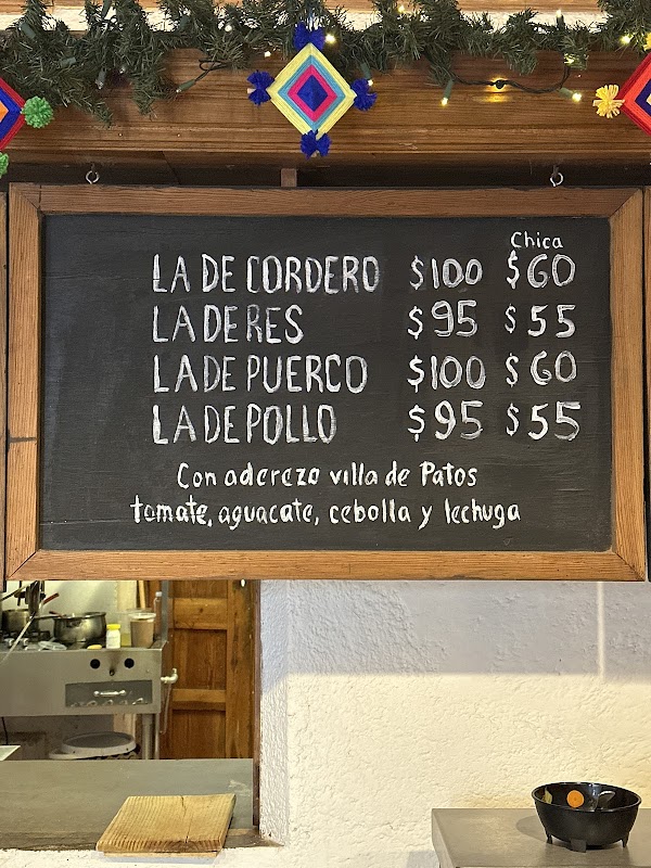 Mostrando la fachada de Super Boxxo con su letrero y una vitrina llena de carnes y embutidos.