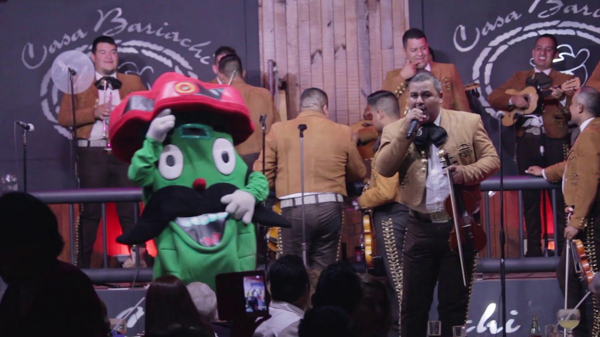 Escenario de Casa Bariachi con músicos de mariachi y una parrilla de arrachera al fondo