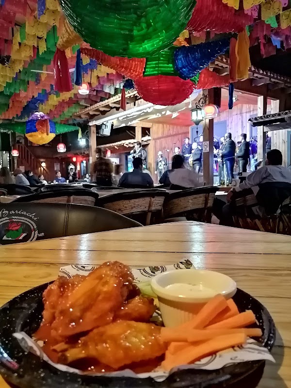 Karne Garibaldi con una olla de carne en su jugo humeante, mostrada en la cocina abierta del restaurante