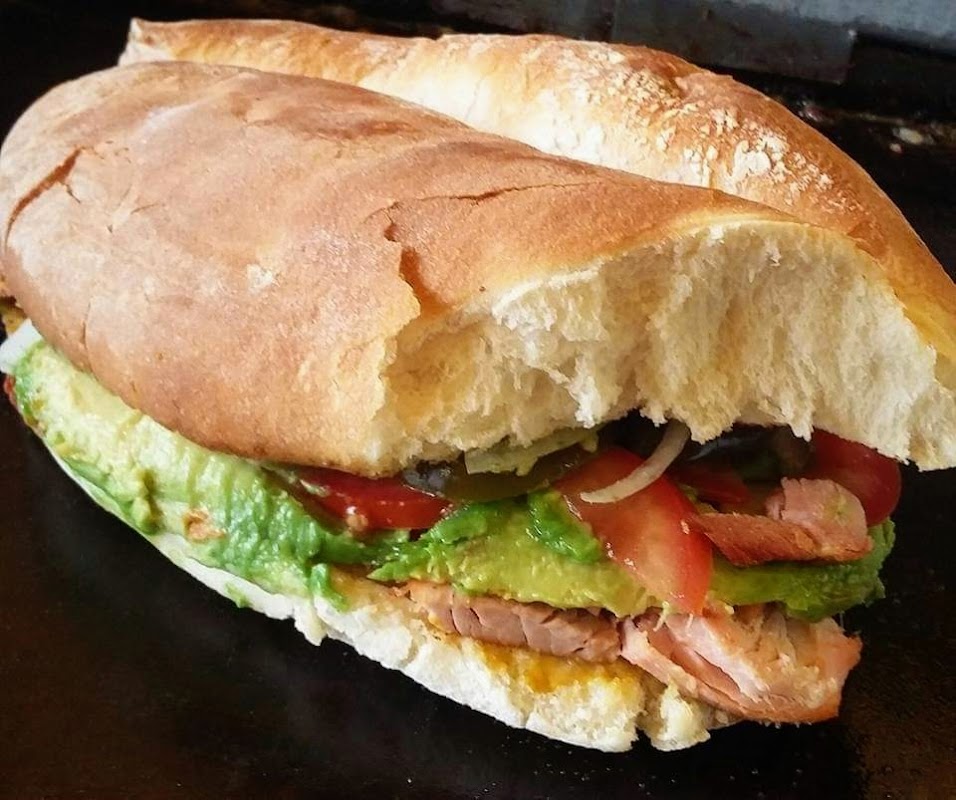 El Taste exterior iluminado con neón y una mesa de tacos bajo la luz de la calle — captura el ambiente nocturno