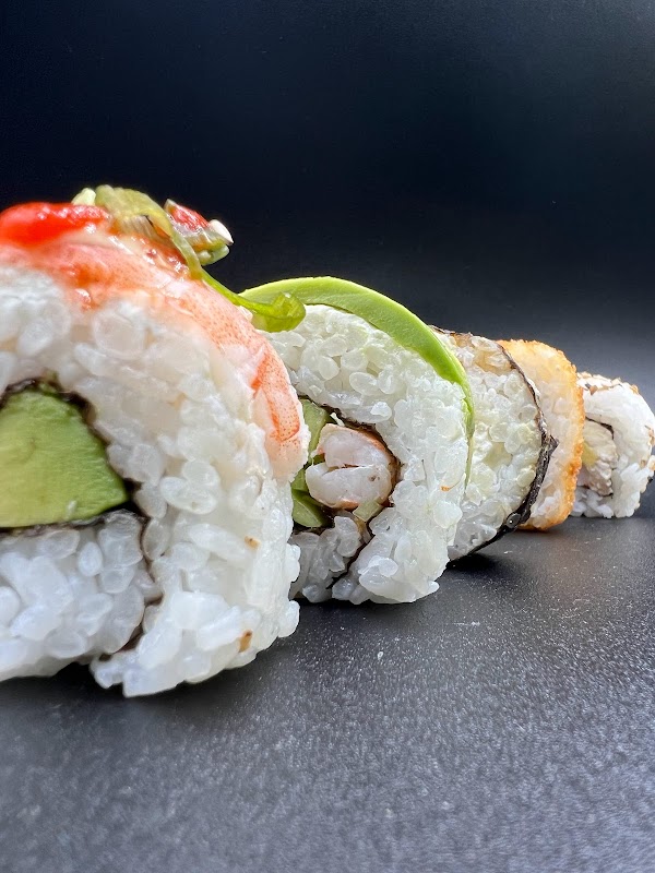 Plato de sushi variado y tacos al estilo callejero servidos en mesas de EL TERRENO FOOD PARK — enfoque en la comida