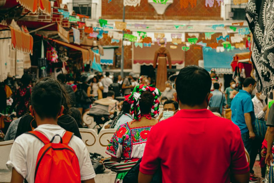 Colorful street festival scene in Puebla, Mexico with traditional clothing and festive atmosphere.