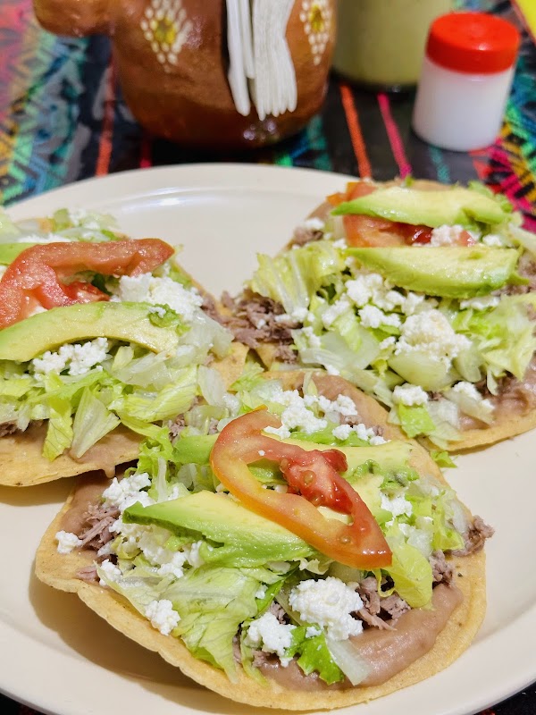 Tazón de pozole pequeño en Los Anafres, con maíz, chicharrón y una rama de cilantro fresca