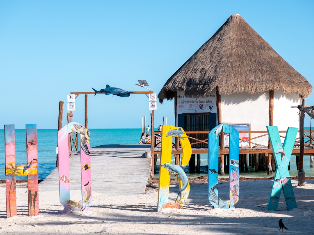 Colorful letters spell out holbox by a beach hut.