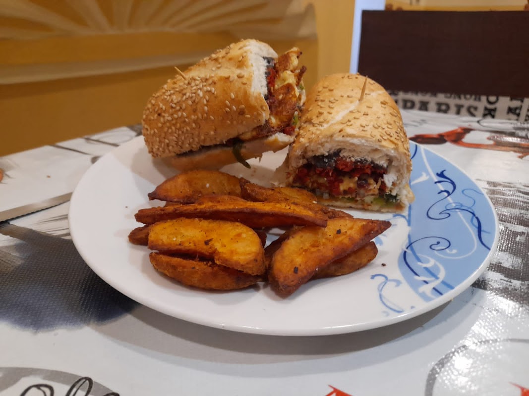 Taquería El Delirio – mostrador con cemitas de milanesa y una jarra de agua de fresa, ambiente callejero