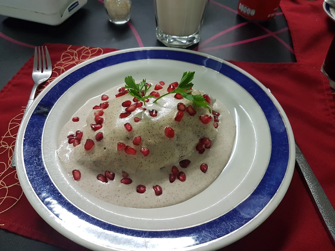 Molcajete humeante y carnitas en La Herradura — vista del interior con mesas de hierro