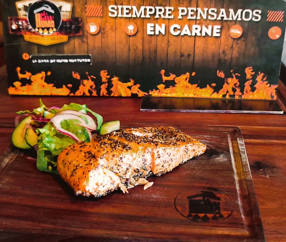 Costillas de cerdo ahumadas en La Casa De Humo, servidas con guarnición y michelada al lado