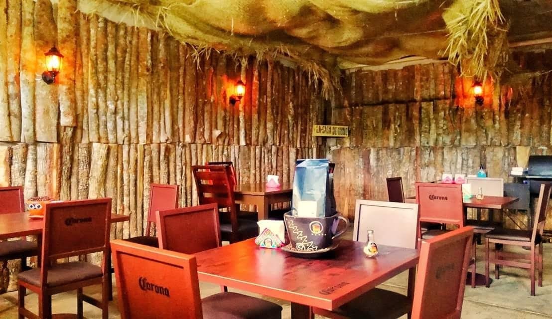 Interior de La Casa De Humo Huatusco, mostrando la parrilla ahumadora y mesas de madera
