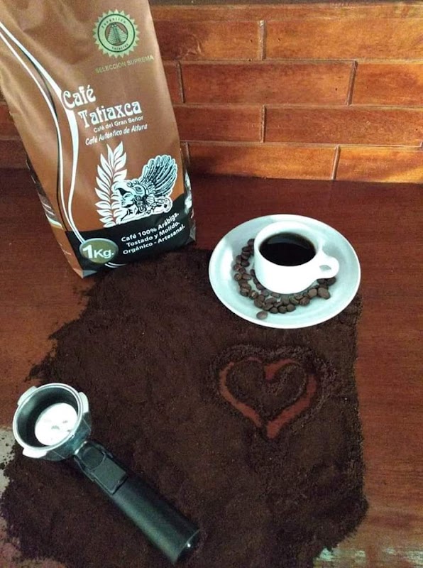 Terraza luminosa de Villa Del Sol Café con mesas de madera y una taza de capuchino sobre la mesa