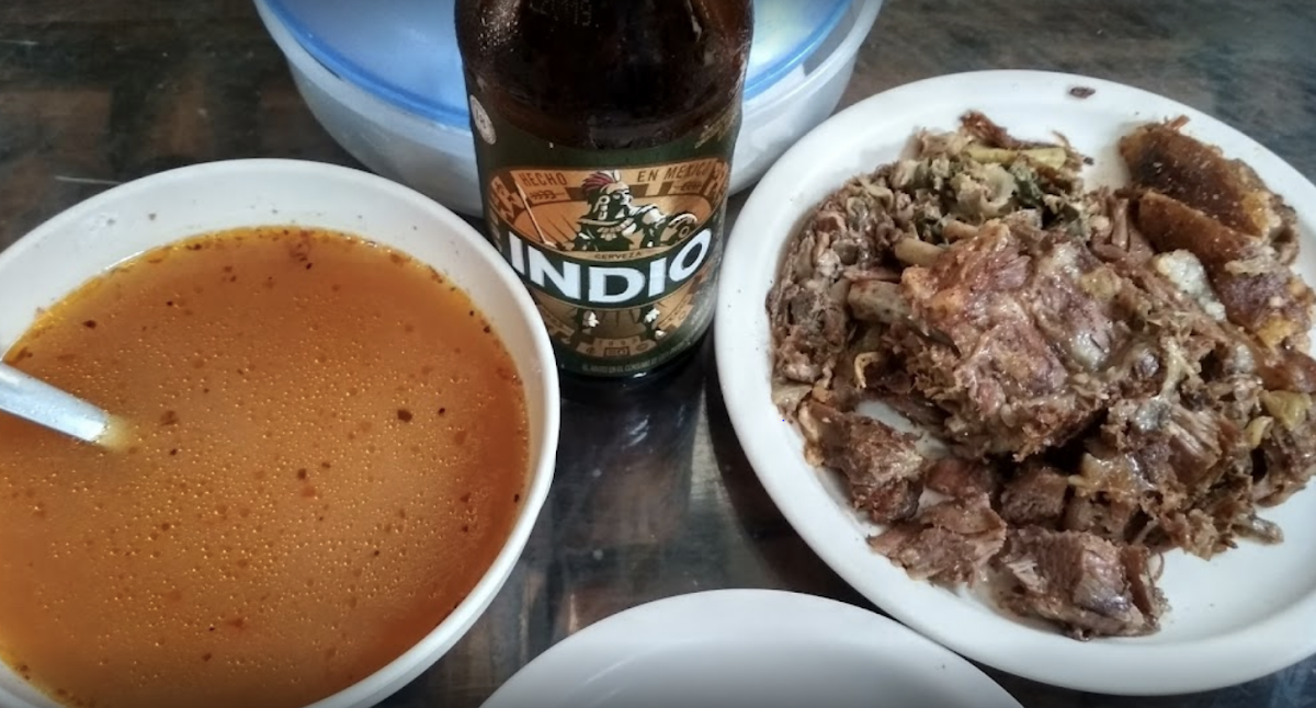 interior de El Taxqueño mostrando tacos de cabra en plato de cerámica y músicos en vivo