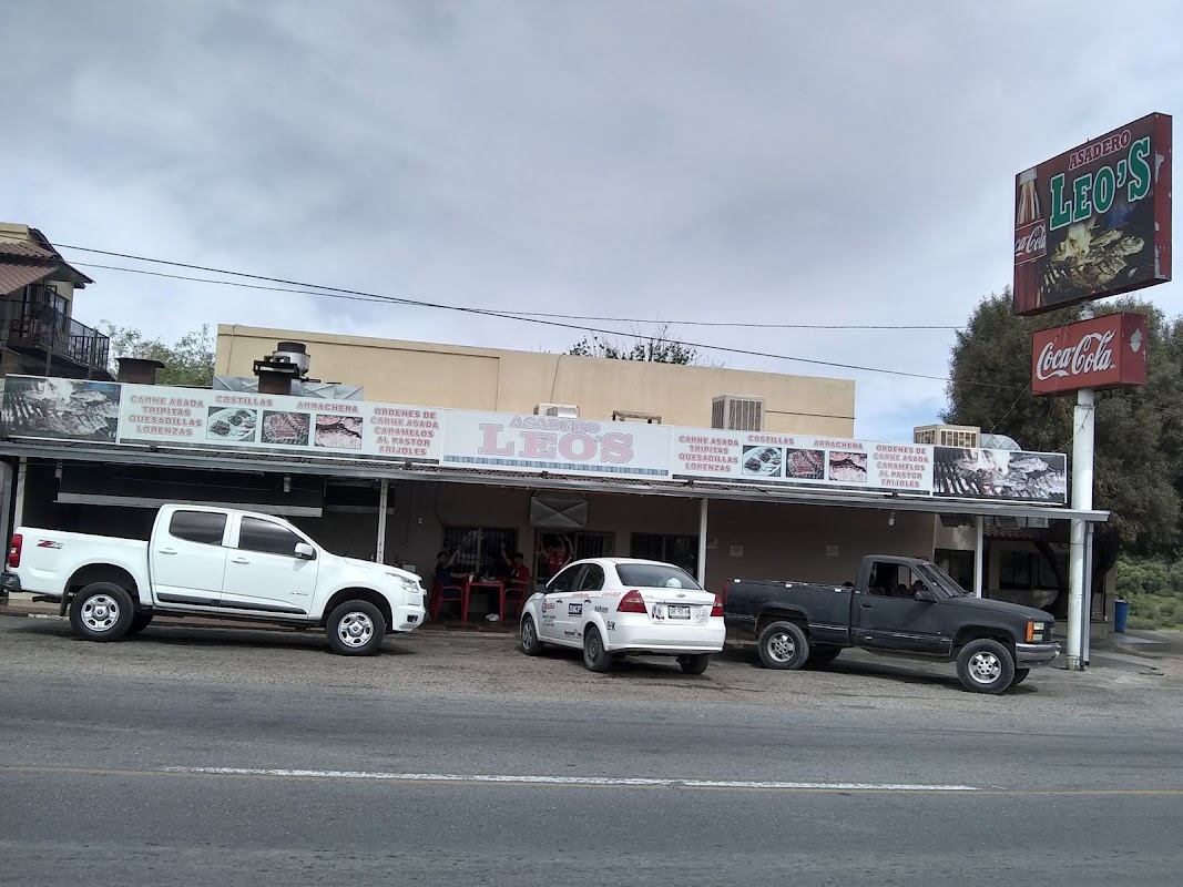 Tacos de carne asada y al pastor en Asadero Leo's, mostrados en el mostrador con salsas y tortillas de harina