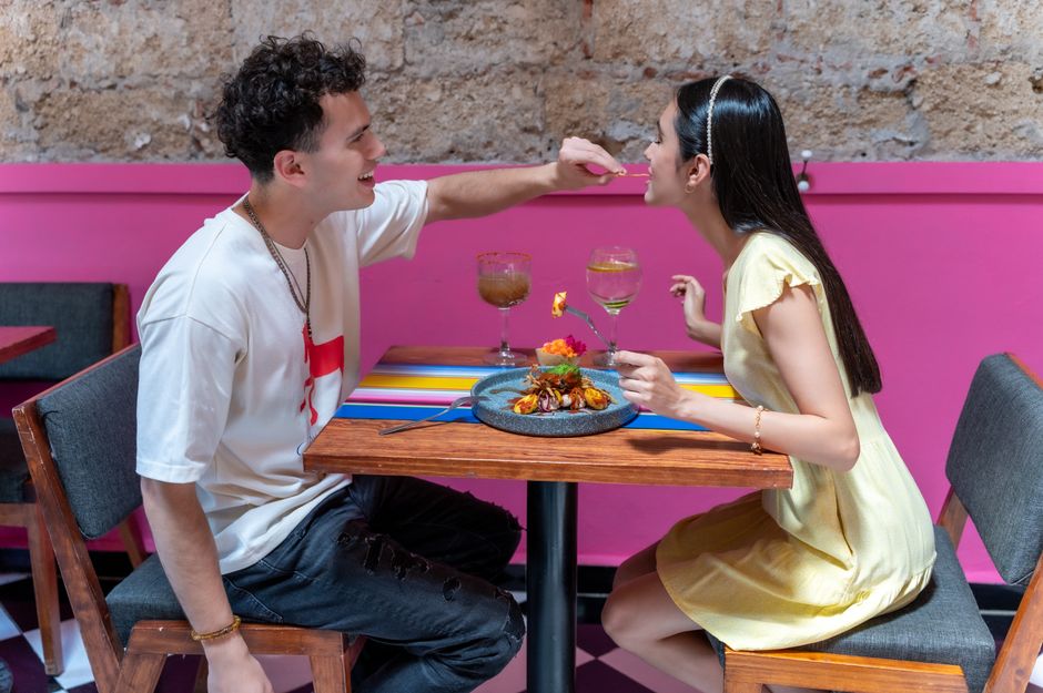 A young couple sharing a meal at a colorful restaurant in Mexico City, CDMX.
