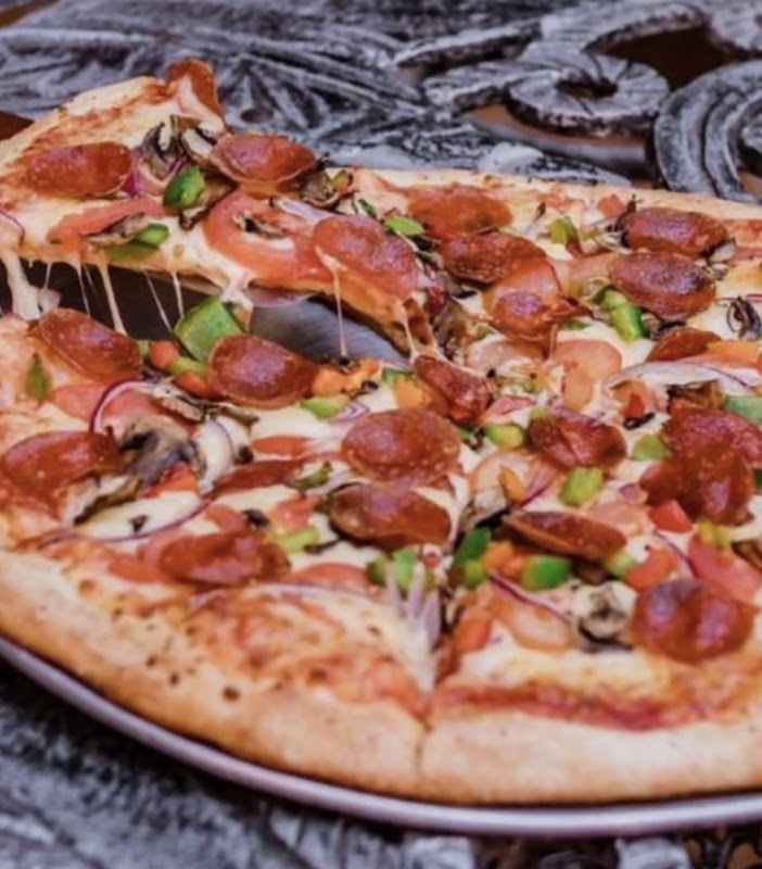Interior de Gabacho´s Pizzeria Ixtlahuacan mostrando el horno de leña y una pizza recién salida