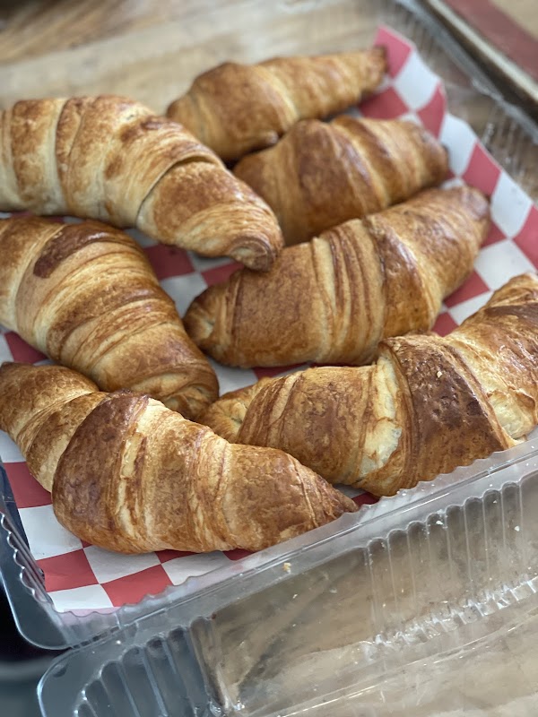 Mostrador de Panadería Artesanal Bakery con panes de masa madre recién horneados y un sándwich de aguacate y queso