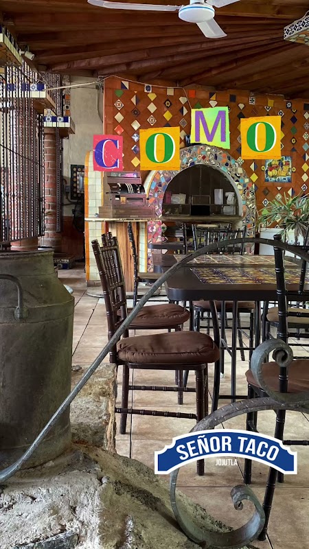 Deliyuz Suc Jojutla – interior del local con mesas de madera y una vitrina que muestra una variedad de platillos tradicionales