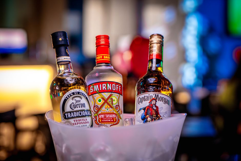 Vibrant shot of liquor bottles in ice bucket, perfect for bar themes.