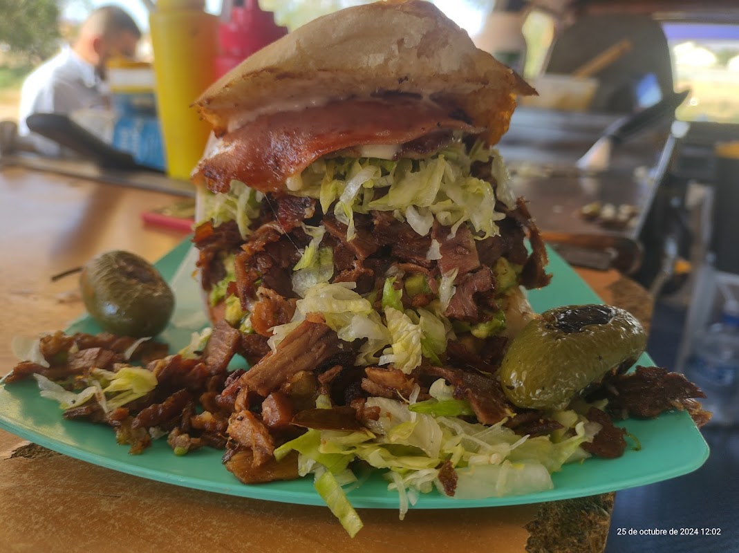 Mariscos Jardín Issa con su buffet de mariscos, camarones y pulpo en una mesa al aire libre bajo sombrillas, vista de la carretera Aldama Km 18.5