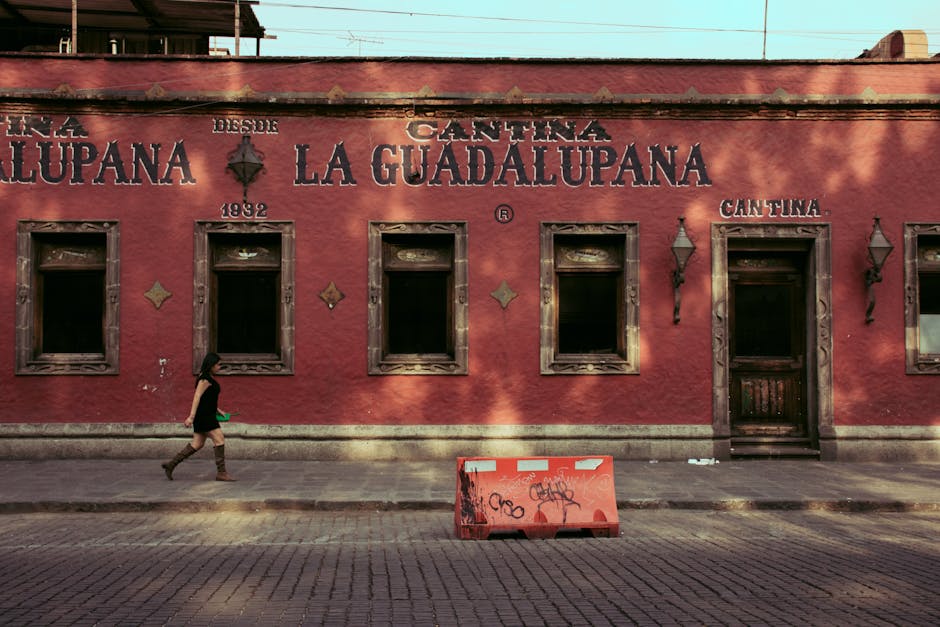 A historic bar in Mexico with a distinctive red facade and vintage architecture.