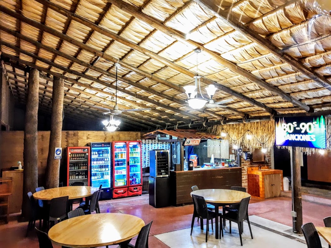 El Mezquite Grill interior con parrilla de leña y plato de filet mignon al punto