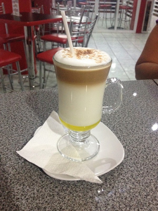Café Oh La La con una taza de espresso y una tarta de queso con frutos rojos en la barra interior