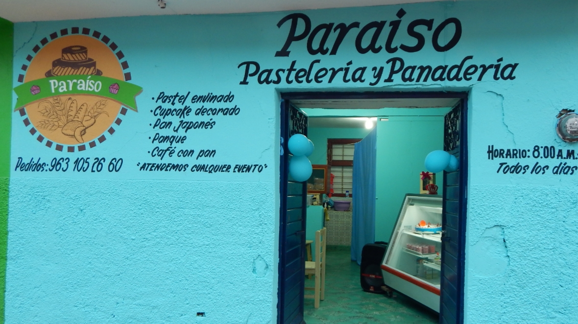 Pastelería y Panadería Paraíso con una bandeja de croissants y conchas recién horneados en el mostrador