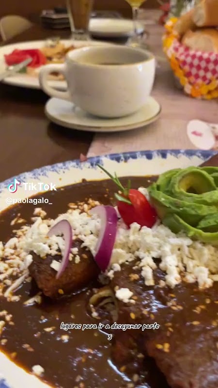 Tazón de ramen humeante en Bake-neko Ramen — interior del local con luces de neón y el ramen en primer plano
