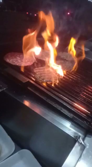 Hamburguesa clásica con queso fundido y papas fritas en Hamburguesas al carbón las del teatro, vista del mostrador de la parrilla