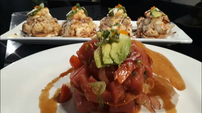 Piranha Sushi – vista interior con mesas ocupadas, énfasis en la variedad de rolls de mariscos