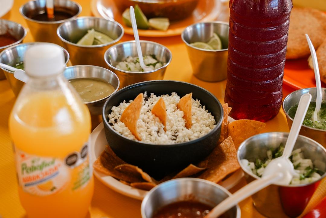 Primer plano de los tacos de birria con su caldo de consomé humeante en La Casa de Lalo