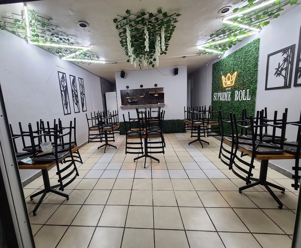 Interior de Supreme Roll con una bandeja de sushi variado y señal de promociones, chefs preparando rolls