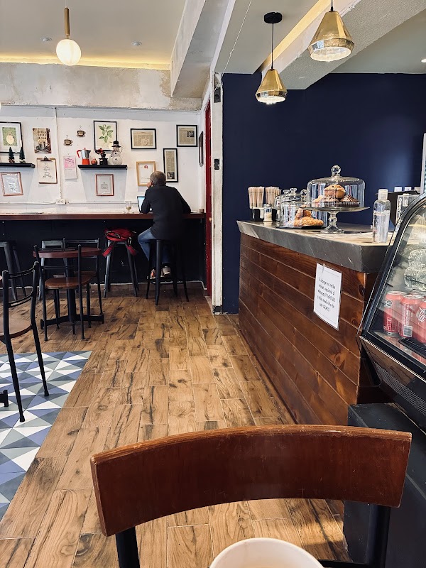 Interior de MALA HIERBA con un matcha latte en taza de cerámica y el menú escrito en pizarra