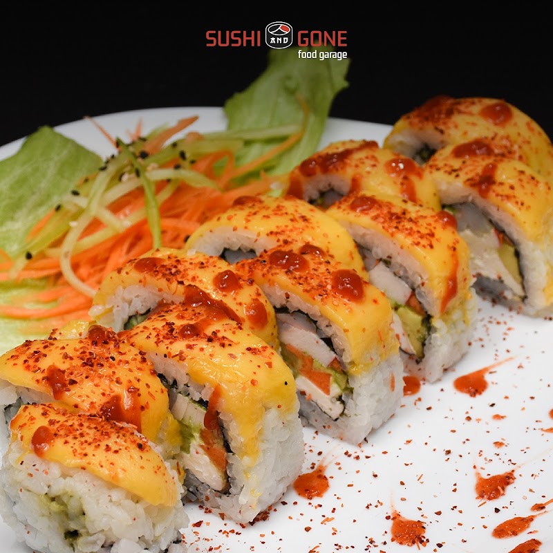 Roll de sushi rainbow en Sushingone Cumbres, con colores vivos y salsa al lado