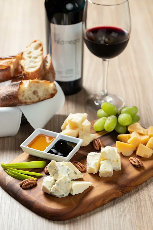 Interior de Assaggio Italian Cuisine, mesas de madera y luz cálida, con clientes disfrutando de la comida