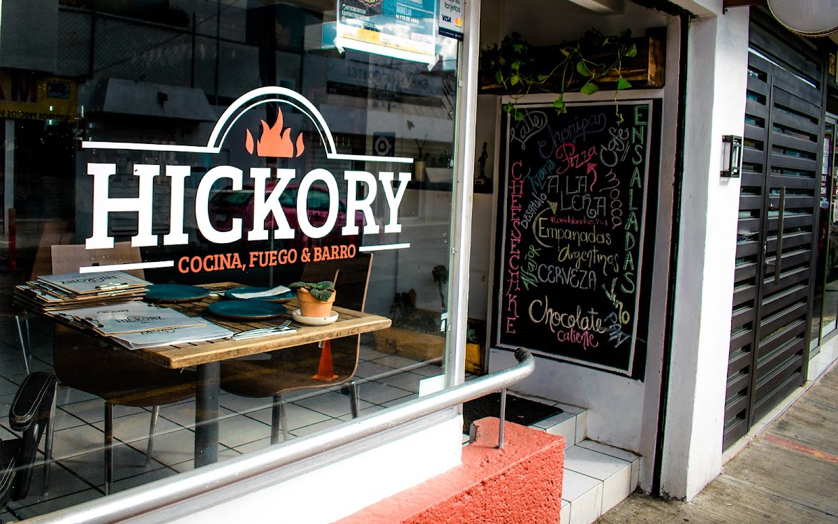 Pizza de la casa en Hickory Morelia, masa crujiente, salsa de tomate, mozzarella fundida y choripán encima — primer plano del plato.