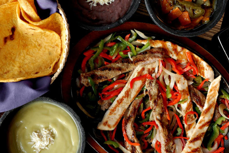 Colorful Mexican fajitas with grilled meat and vegetables, served with tortillas and sauces.