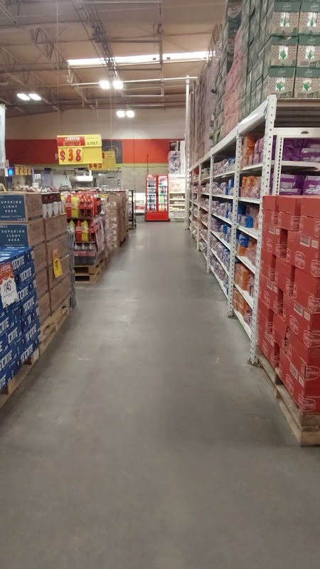 Soriana Express Naranjos — pasillo de la sección de panadería con estantes llenos de bollos y una caja registradora brillante bajo luces de la tienda