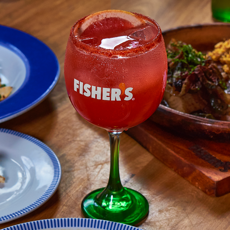Interior of Fisher's during lunch rush, with patrons at the bar and chefs preparing tacos